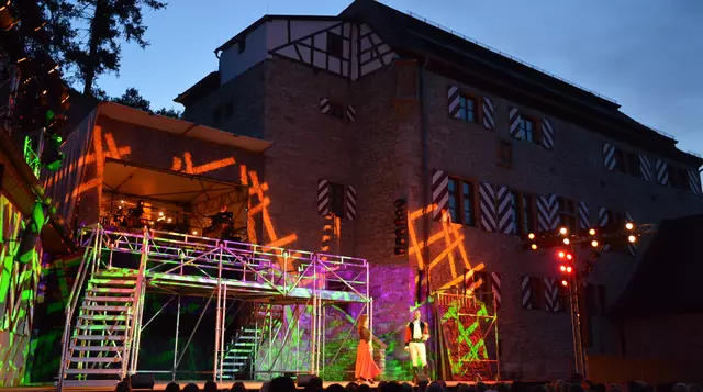Festspielbühne im Burghof mit bunten Lichtern